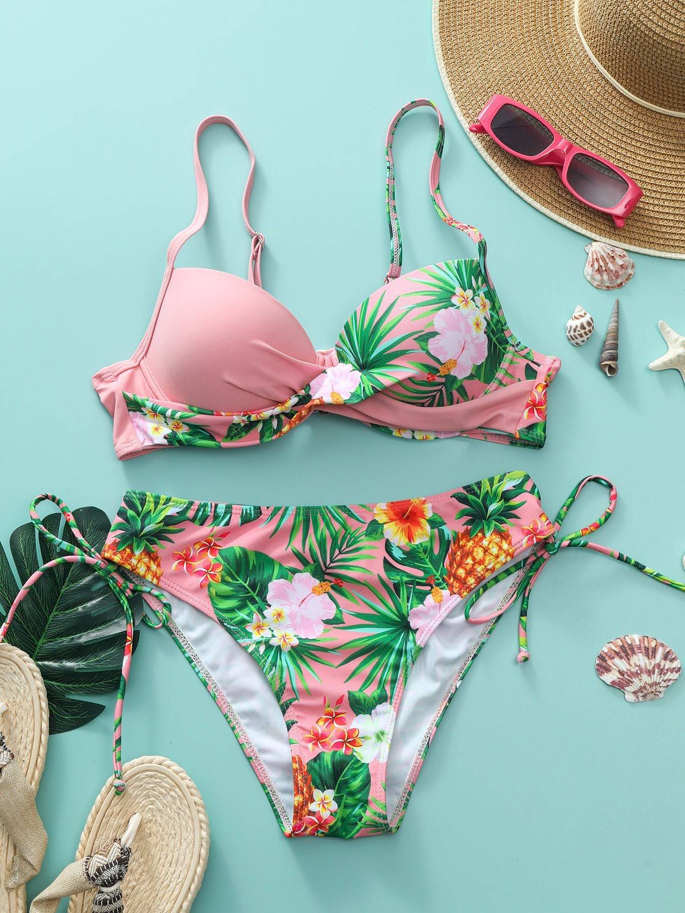 Розов бански от две части ''Reflection'' с флорални мотиви, представен с плажни аксесоари. Комплектът включва горнище с подплънки и класическо долнище.