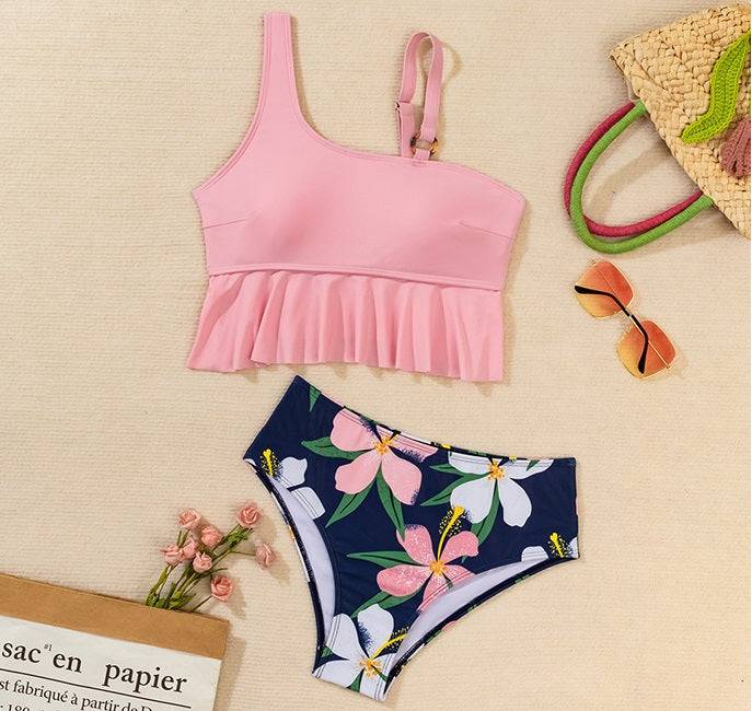 Дамски бански ''Crystal'' в розово с флорално долнище, представен с аксесоари за плаж.